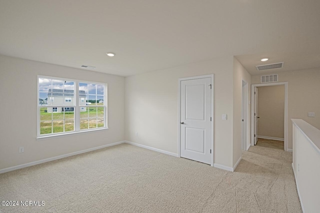 empty room with recessed lighting, baseboards, light carpet, and visible vents