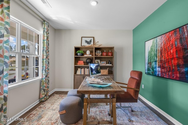 home office with visible vents, baseboards, and wood finished floors