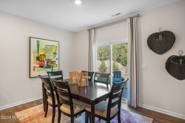 dining space featuring visible vents, baseboards, and wood finished floors