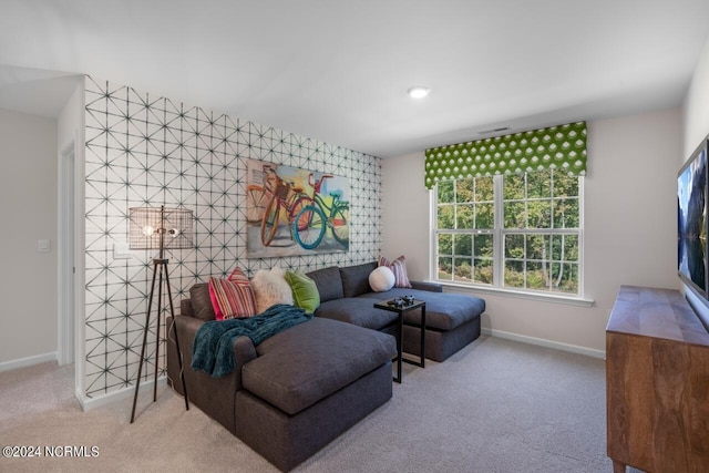 carpeted living room with an accent wall and baseboards