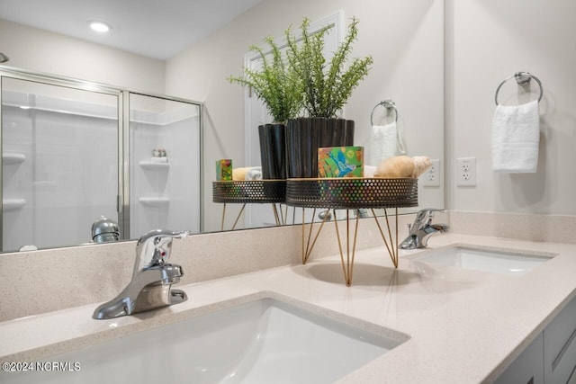 full bath featuring a sink, double vanity, and a shower stall