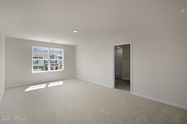 carpeted spare room featuring baseboards