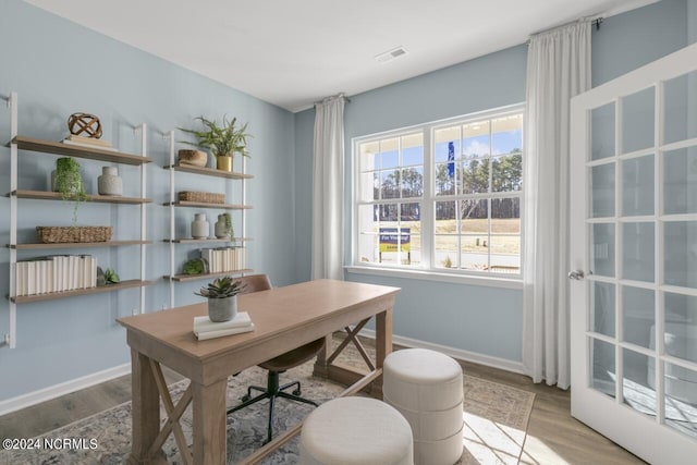 office space featuring visible vents, baseboards, and wood finished floors