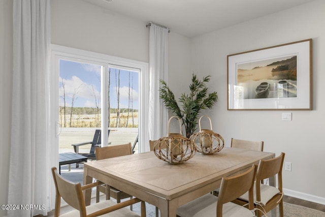 dining area with baseboards and wood finished floors