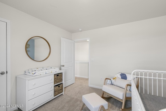 bedroom with light colored carpet and baseboards