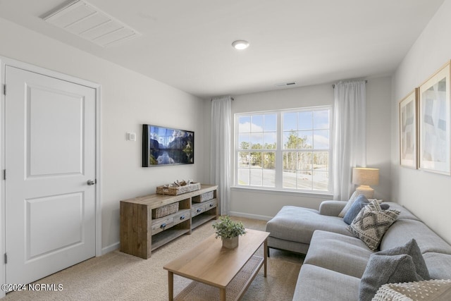 living room with light carpet, visible vents, and baseboards