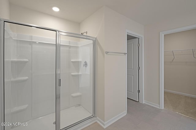 full bath featuring a walk in closet, recessed lighting, baseboards, and a stall shower