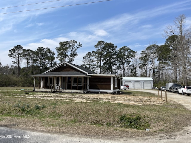 view of front of home with an outbuilding, a porch, and driveway