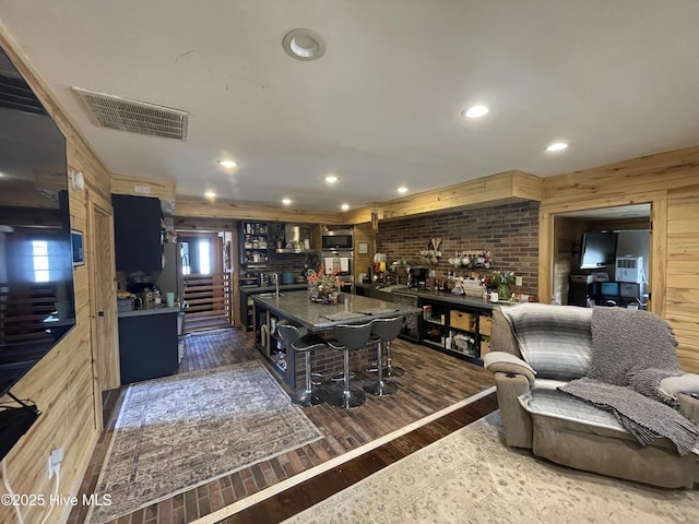 interior space featuring wooden walls, recessed lighting, visible vents, and dark wood-style flooring