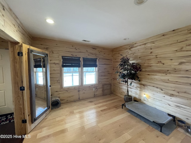 interior space featuring recessed lighting, visible vents, light wood-style floors, and wooden walls