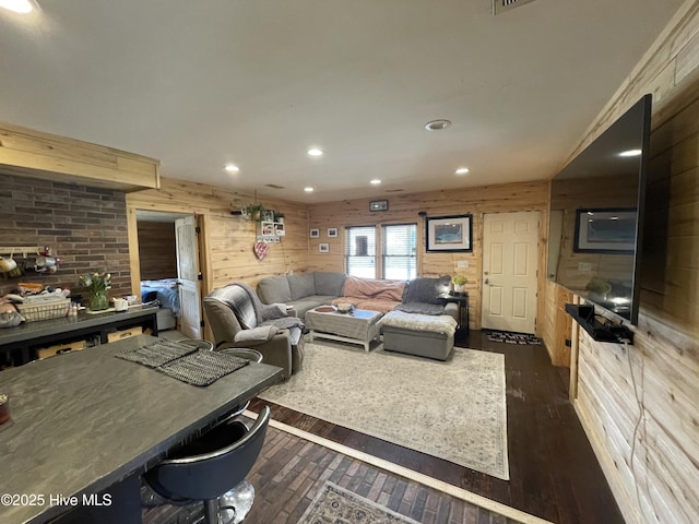 living room featuring recessed lighting, dark wood-style flooring, and wood walls