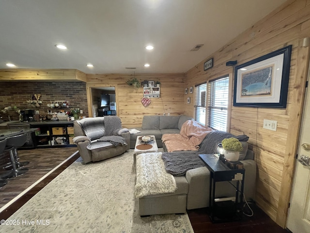 living room featuring visible vents, recessed lighting, wooden walls, and wood finished floors