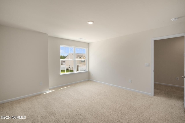 unfurnished room with baseboards and carpet