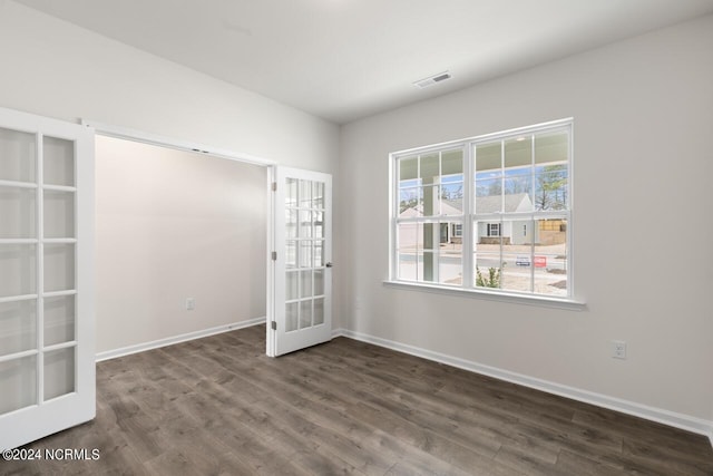 spare room with dark wood-style floors, visible vents, french doors, and baseboards