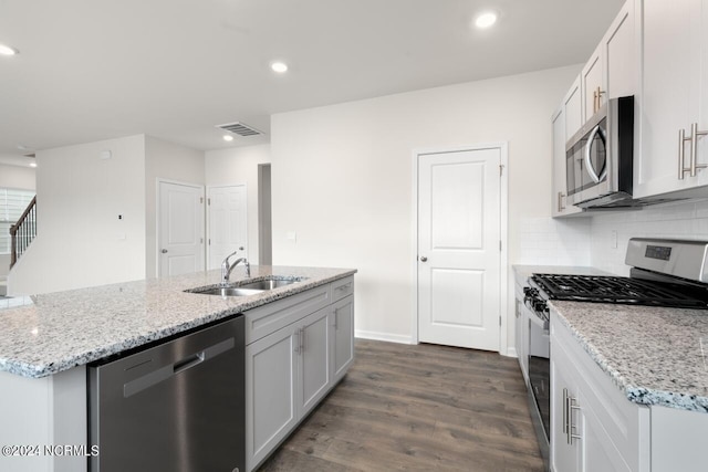 kitchen featuring visible vents, dark wood-type flooring, a sink, tasteful backsplash, and appliances with stainless steel finishes