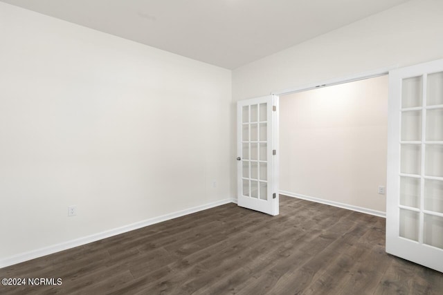 spare room featuring french doors, baseboards, and dark wood-style floors