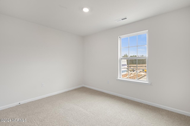 spare room with recessed lighting, carpet, visible vents, and baseboards