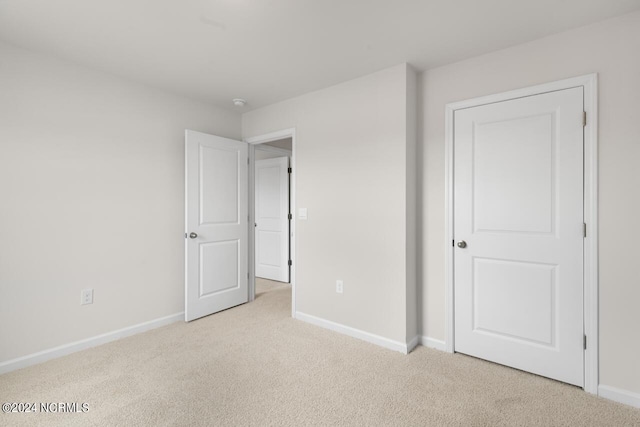 unfurnished bedroom featuring carpet and baseboards