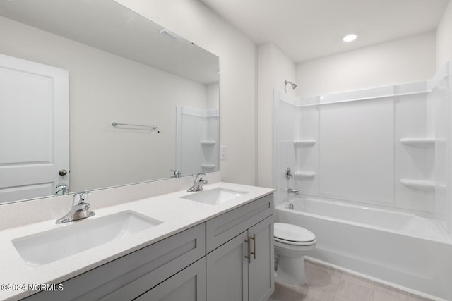 bathroom with a sink, shower / bathtub combination, toilet, and double vanity