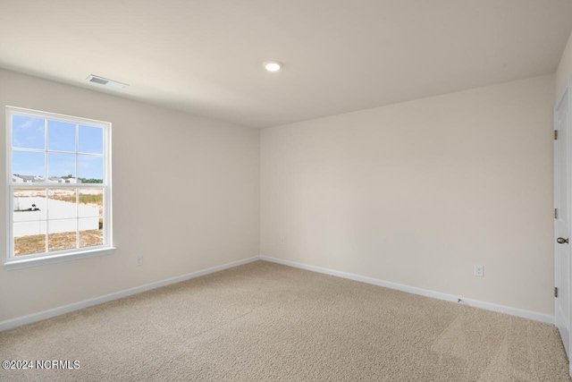 unfurnished room featuring visible vents, baseboards, and carpet