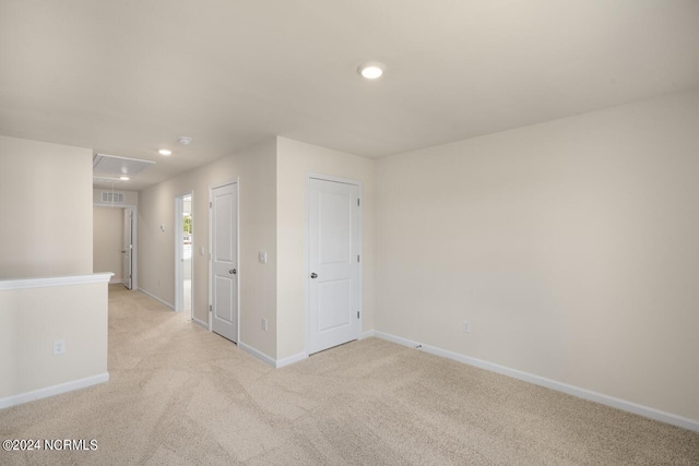 spare room with visible vents, baseboards, attic access, recessed lighting, and light carpet