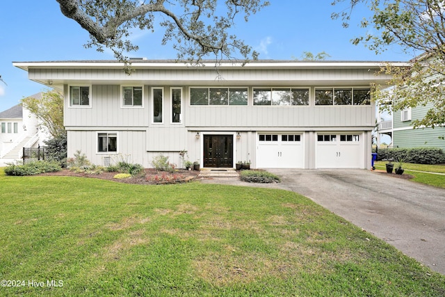 view of front of house featuring driveway, an attached garage, and a front lawn