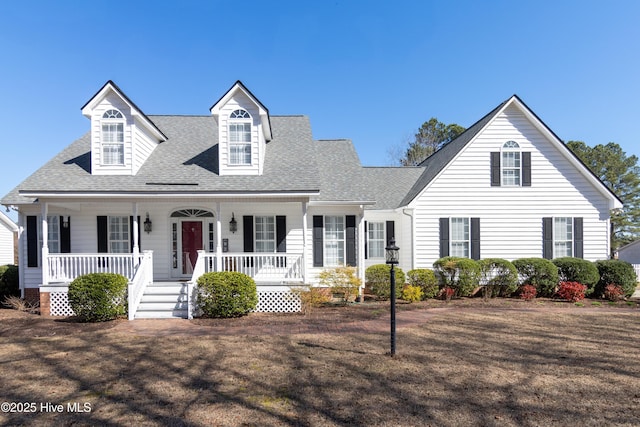 new england style home with covered porch and a shingled roof