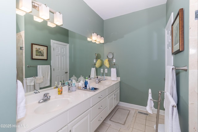 full bath featuring tile patterned floors, visible vents, double vanity, and a sink