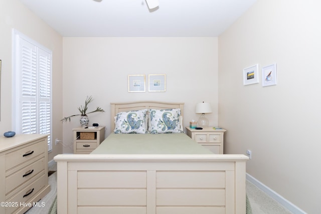 bedroom featuring baseboards and light colored carpet