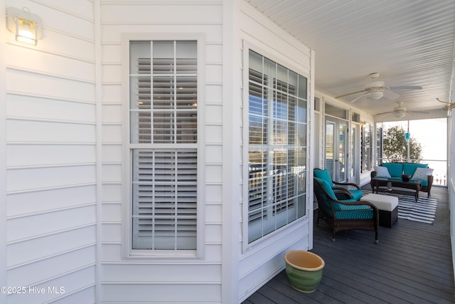 wooden terrace featuring covered porch and a ceiling fan