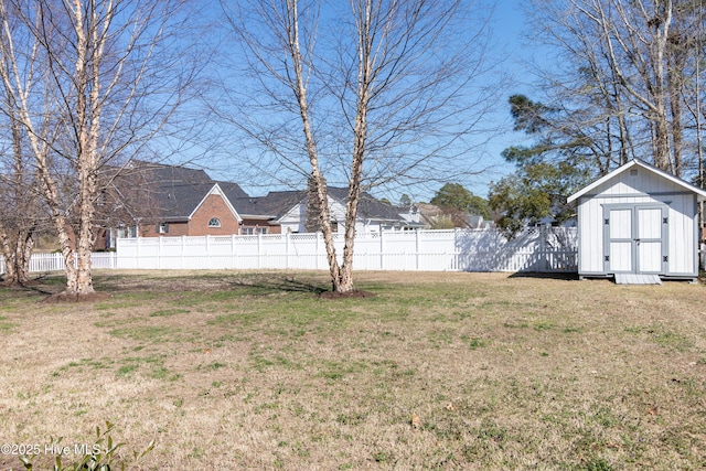 view of yard featuring an outbuilding, a shed, and fence