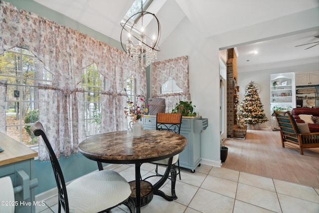 dining area with crown molding, light tile patterned floors, and ceiling fan with notable chandelier