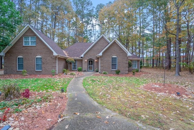 view of front of house featuring brick siding and a front lawn