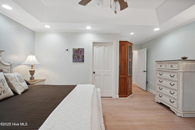 bedroom featuring light wood finished floors, recessed lighting, crown molding, and a raised ceiling