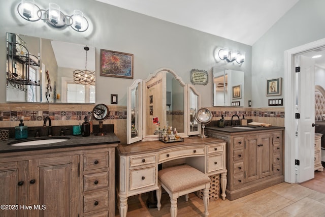 bathroom featuring tile patterned flooring, vanity, and lofted ceiling