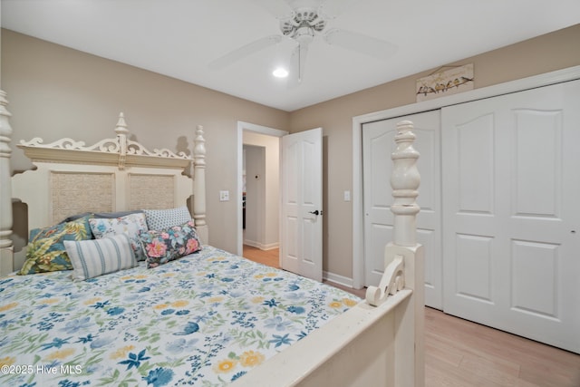 bedroom with baseboards, light wood-style floors, a closet, and ceiling fan