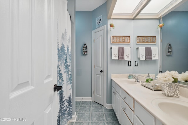 bathroom featuring a sink, baseboards, double vanity, and tile patterned flooring