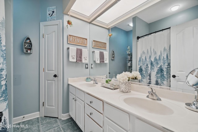 bathroom with double vanity, tile patterned floors, baseboards, and a sink