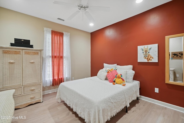 bedroom featuring multiple windows, wood finished floors, and baseboards