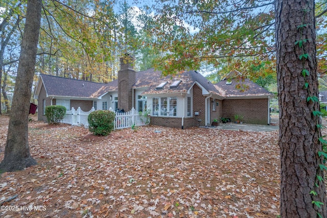 ranch-style home with a gate, brick siding, a chimney, and fence