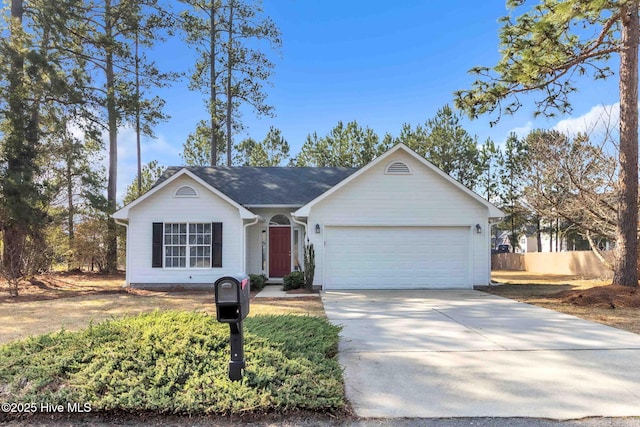 ranch-style home featuring concrete driveway, an attached garage, and fence