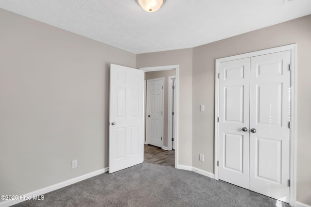 unfurnished bedroom featuring carpet, baseboards, and a closet