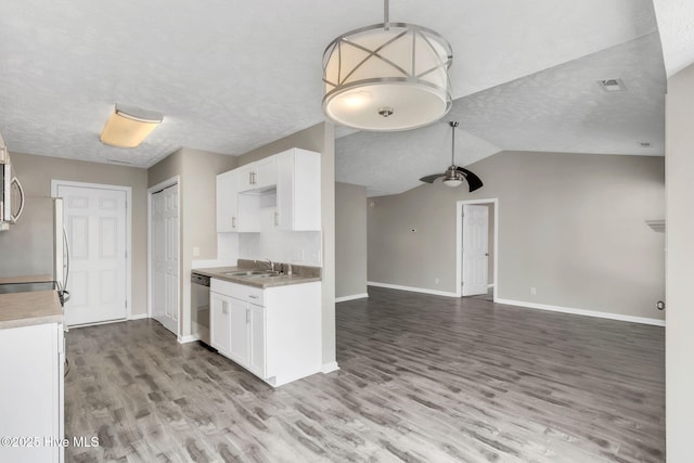 kitchen featuring light wood-type flooring, appliances with stainless steel finishes, open floor plan, and white cabinetry