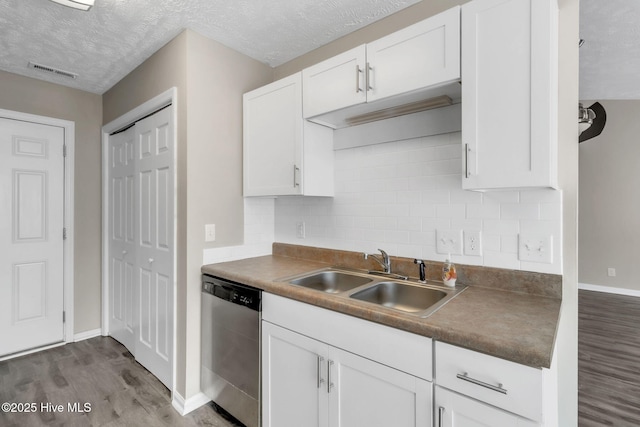 kitchen featuring visible vents, a sink, stainless steel dishwasher, wood finished floors, and white cabinets