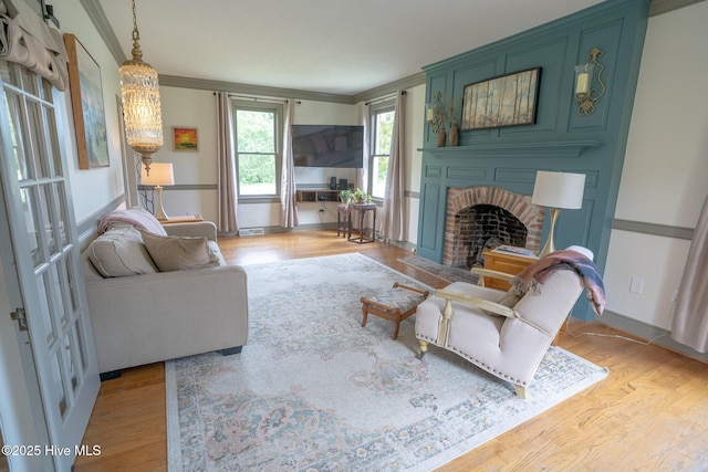 661 Main St, Swansboro, NC 28584 - living area with light wood finished floors, ornamental molding, a brick fireplace, and baseboards
