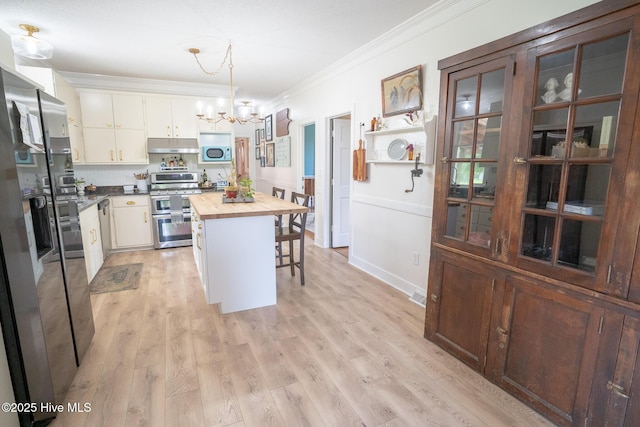 661 Main St, Swansboro, NC 28584 - kitchen featuring double oven range, wooden counters, ornamental molding, a chandelier, and under cabinet range hood