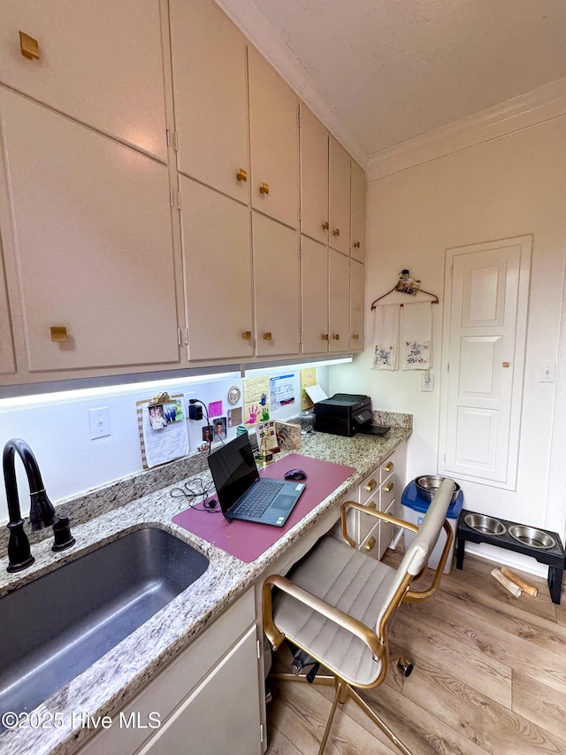office with a sink, wood finished floors, and ornamental molding
