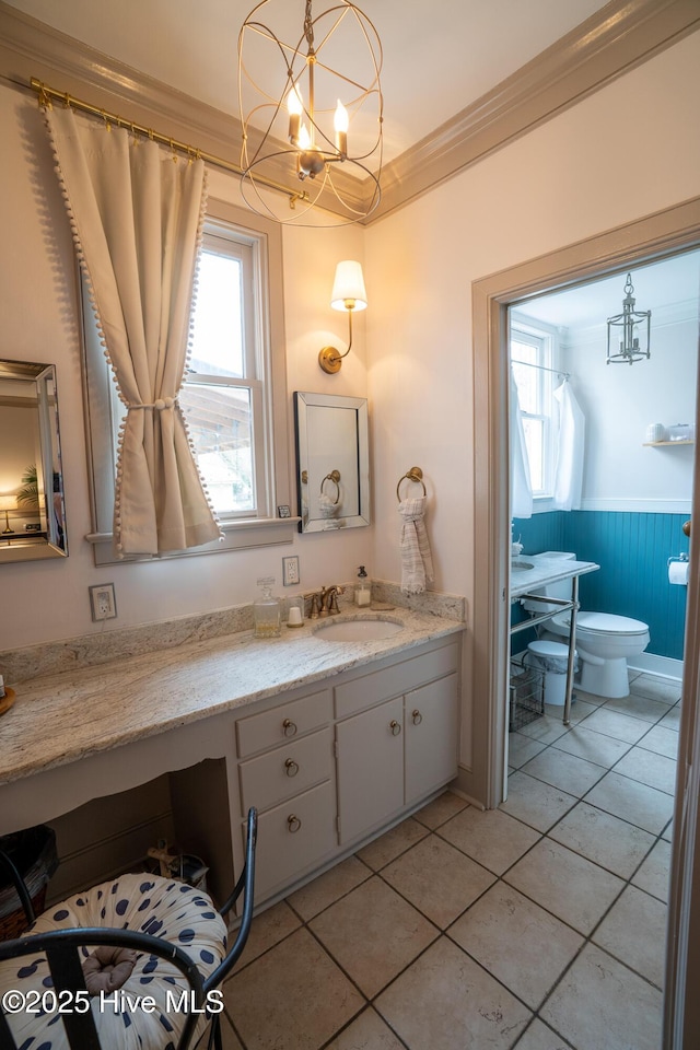 bathroom featuring a notable chandelier, vanity, toilet, tile patterned floors, and ornamental molding