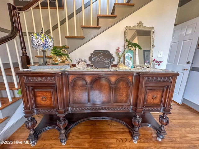 interior space with stairs, baseboards, and wood finished floors