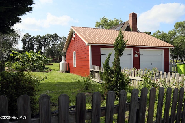 661 Main St, Swansboro, NC 28584 - view of home's exterior featuring metal roof, a chimney, and a detached garage